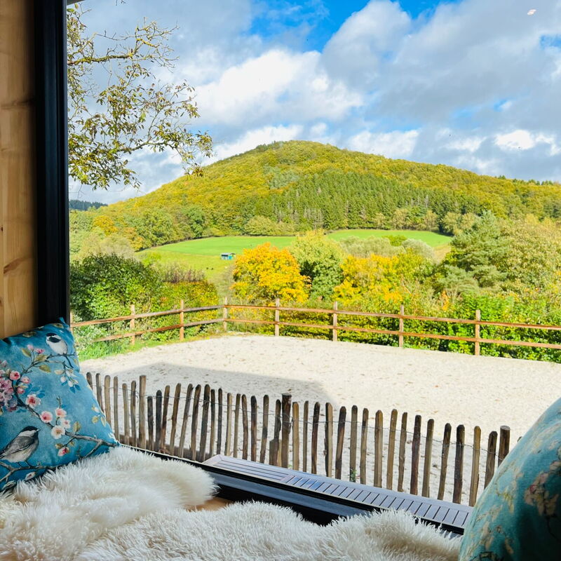 Ein Sitzfenster aus Zirbenholz gibt den Blick auf eine wunderbare Landschaft frei