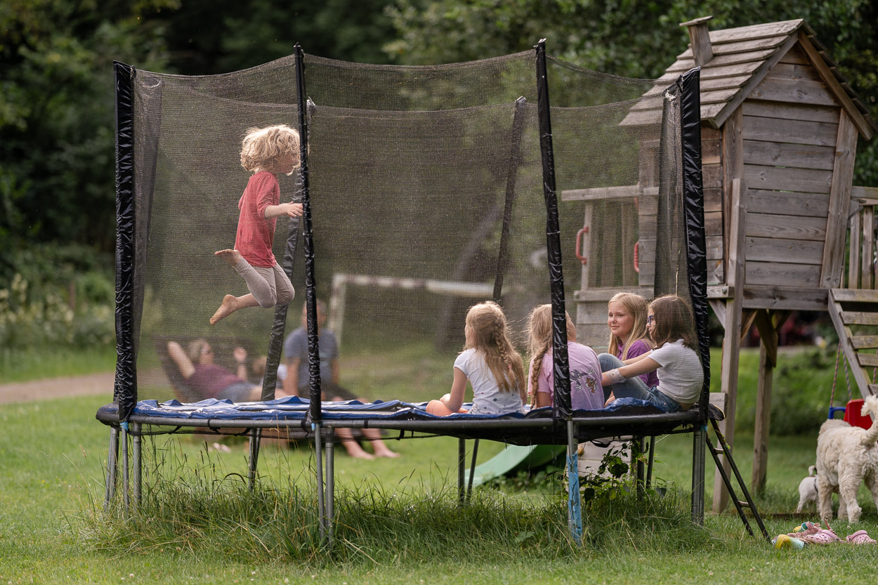 Kinder springen auf einem Trampolin auf dem Landgut Pfauenhof in der Eifel.